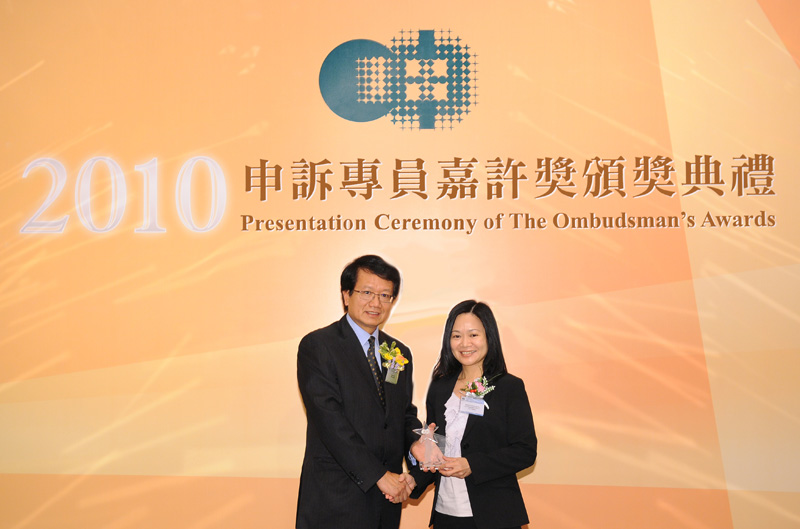 The Ombudsman, Mr Alan Lai (left) presents the trophy for The Ombudsman's Awards for Officers of Public Organisations to Ms Hayley MAK, Land Registration Officer II of the Land Registry