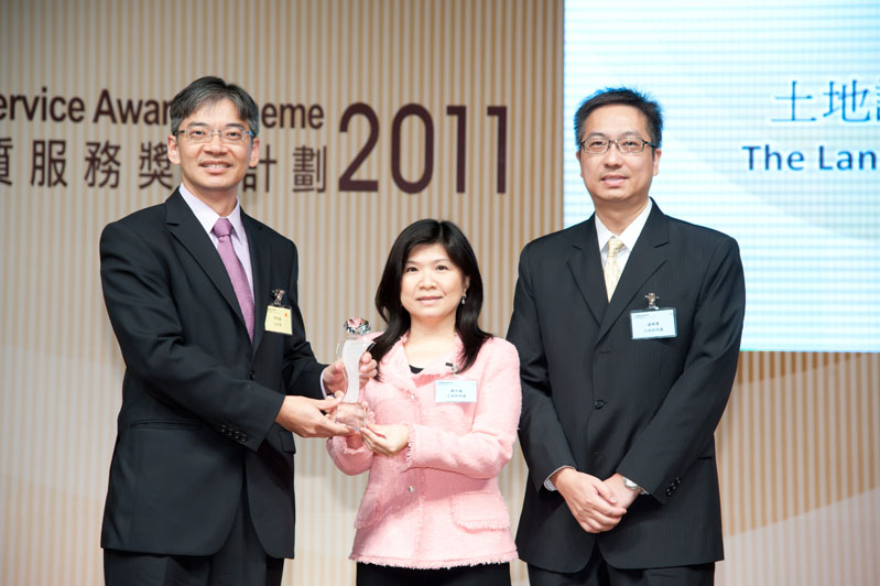 Legislative Council Member, Dr Leung Ka-lau (left) presents the trophy for the Bronze Prize of Departmental Service Enhancement Award (Small Department Category) to the Land Registrar, Ms Olivia Nip (centre)