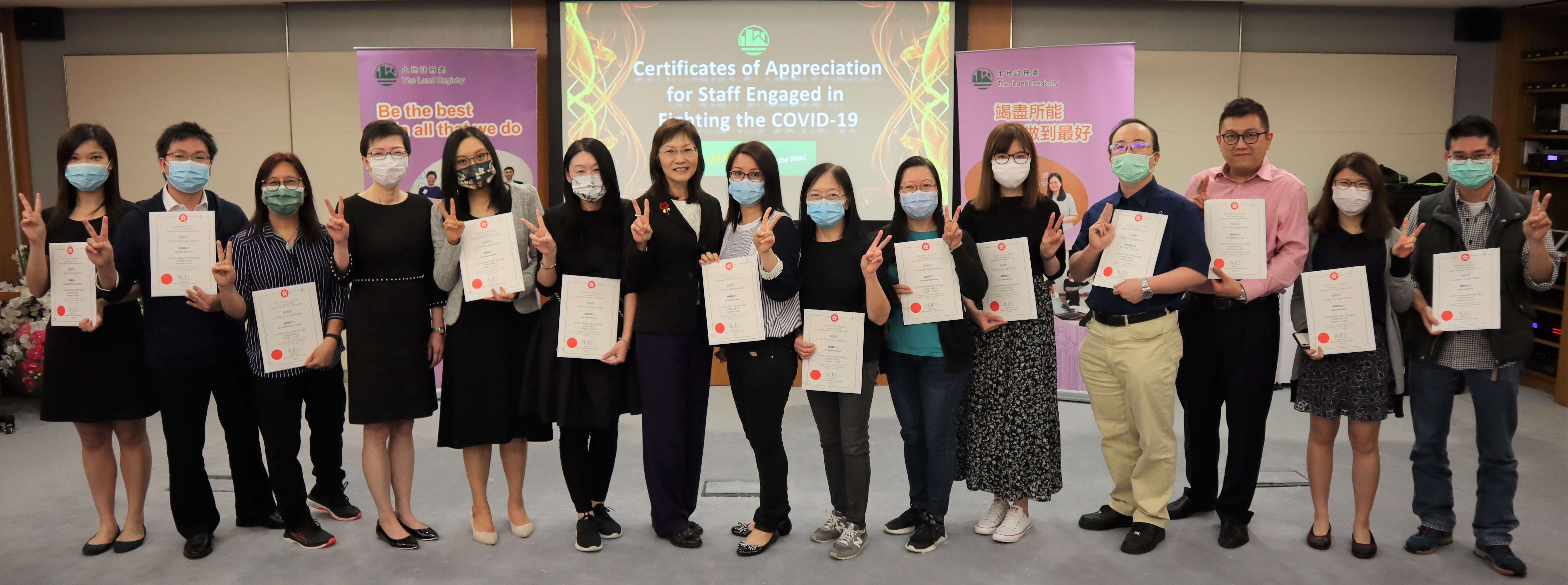 The Land Registrar, Ms Doris CHEUNG, JP (seventh from the left), presents the Certificate of Appreciation issued by the Chief Secretary for Administration for staff engaged in fighting against the pandemic