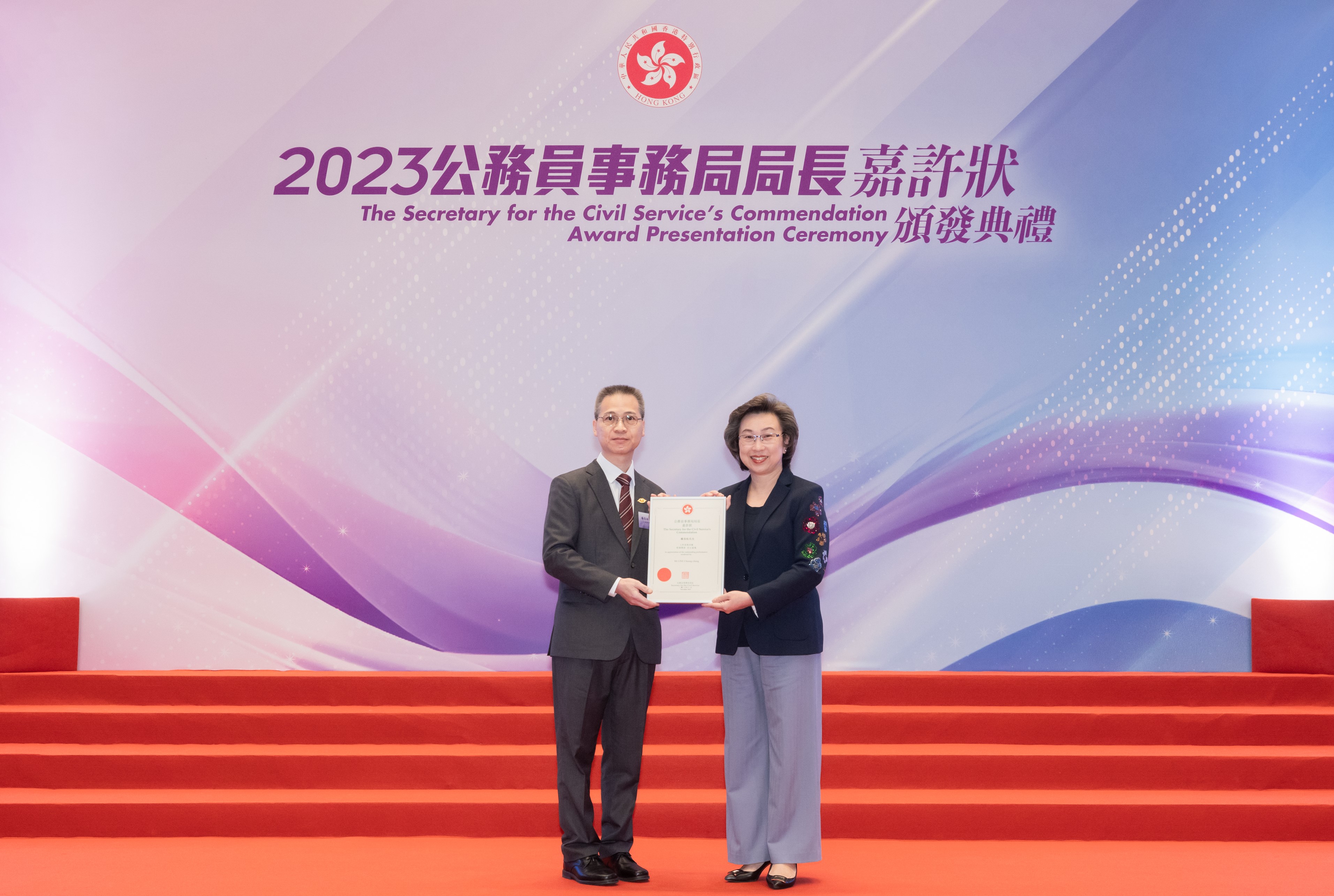 The Secretary for the Civil Service, Mrs YEUNG HO Poi-yan, Ingrid, JP (right) presented The Secretary for the Civil Service's Commendation Award to Clerical Officer of the Land Registry, Mr LINE Cheung-chung