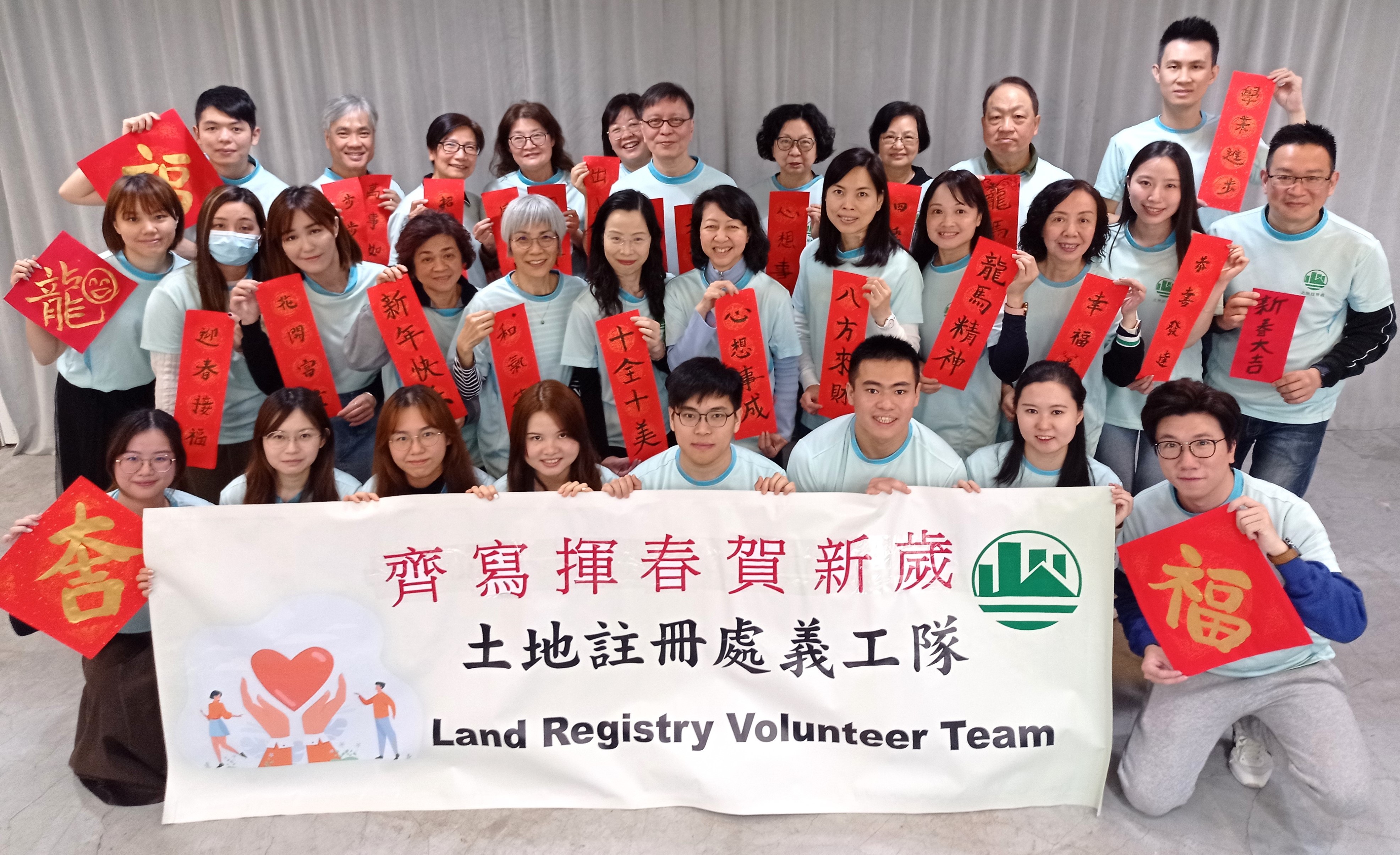The Land Registrar, Ms Joyce TAM, JP (sixth from the right, second row) led the Volunteer Team of the Land Registry to write “Fai Chun” for festive celebration
